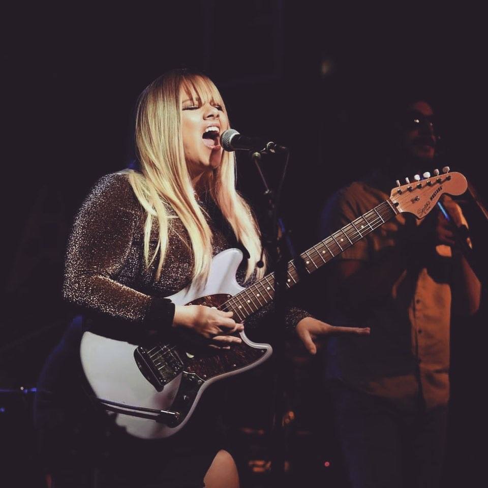 Musician Claire Liparulo playing guitar and singing